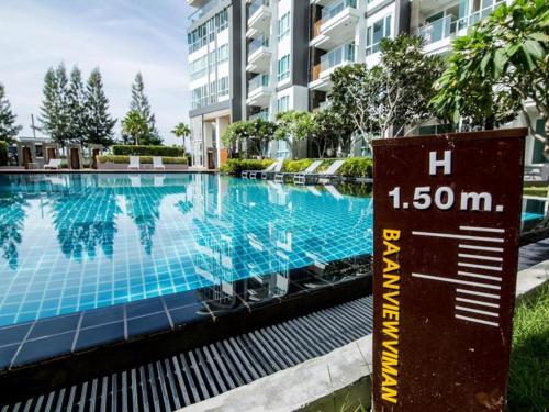 a swimming pool with a sign in front of a building at Ban View Viman Condo in Hua Hin