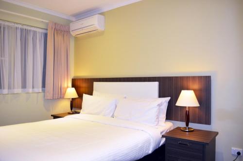 a hotel room with a bed and two lamps at Best Western Plus Buckingham International in Moorabbin