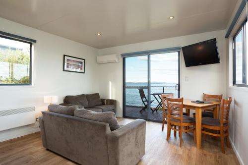 a living room with a couch and a table at Swansea Beach Chalets in Swansea