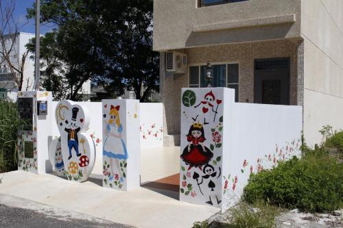 a white fence with paintings on it in front of a building at Na Na Ya Ji Bed and Breakfast in Taitung City