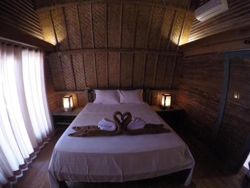a bedroom with a bed with two towels on it at Gili Kulemba Bungalow in Gili Trawangan