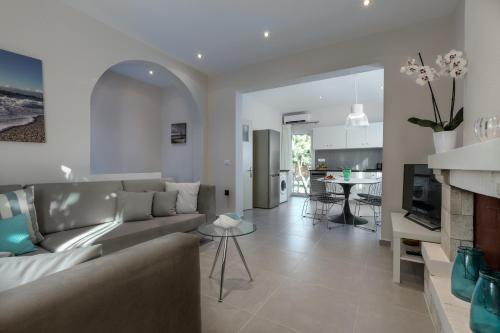 a living room with a couch and a kitchen at Acharavi Beach Hotel in Acharavi