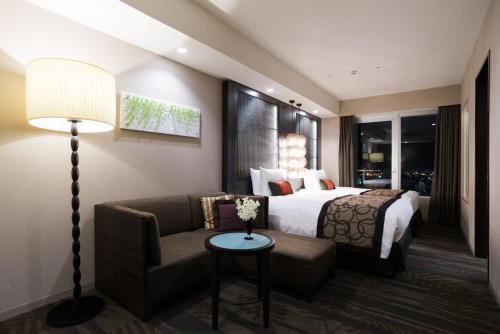 a hotel room with a bed and a couch at Rihga Royal Gran Okinawa in Naha