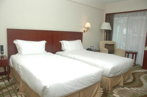 Ένα ή περισσότερα κρεβάτια σε δωμάτιο στο Jianguo Hotel