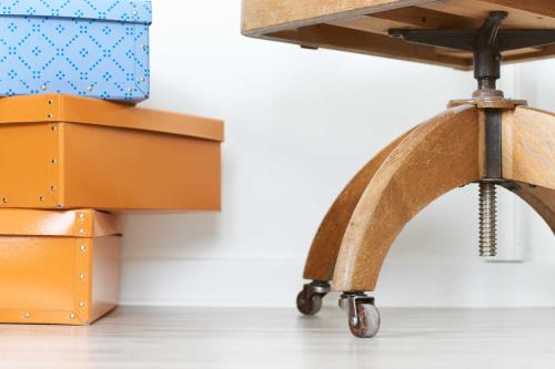 a wooden stool next to a pile of boxes at Pensionat Augustin in Gällivare