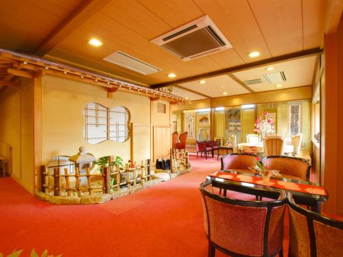 un restaurante con mesas y sillas en una habitación en Kanouya, en Omachi