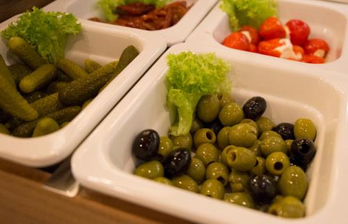 four plastic containers filled with different types of vegetables at Hotel Metropol by Maier Privathotels in Munich