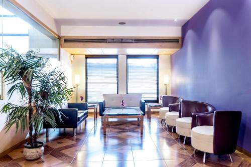 a waiting room with chairs and a table at The Royal Orchid Hotel, Chembur in Mumbai