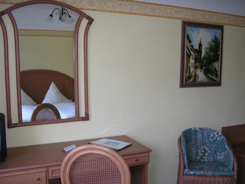 a bedroom with a mirror and a desk and a bed at Pension Villa Beer in Stralsund