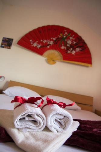 a pair of towels on a bed with an umbrella at Airport Apartments in Belgrade