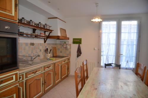 une cuisine avec une table en bois et une salle à manger dans l'établissement Maison de vacance au coeur du village, à Saint-Trojan-les-Bains