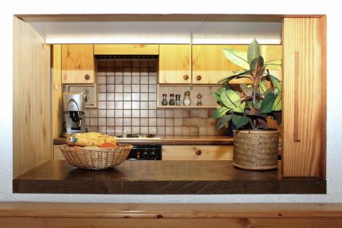 a kitchen counter with a basket of fruit and a plant at Haus Azalea in Davos