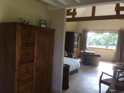a bedroom with a bed and a dresser and a window at L'auberge du Mont in Le Breuil-en-Auge