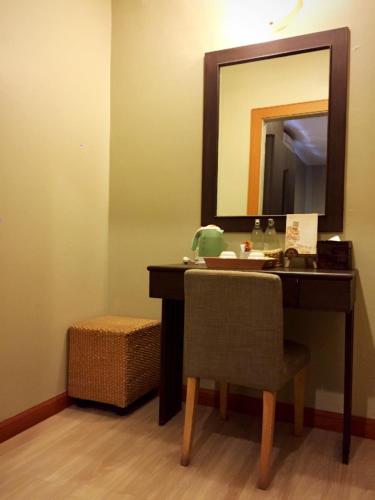 a bathroom with a vanity with a mirror and a chair at Hua Hin White Sand in Hua Hin