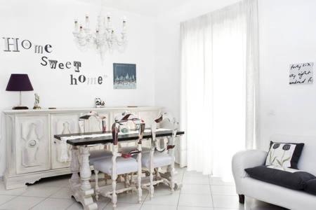 ein weißes Esszimmer mit einem Tisch und Stühlen in der Unterkunft A Casa Mia Apartment in Catania