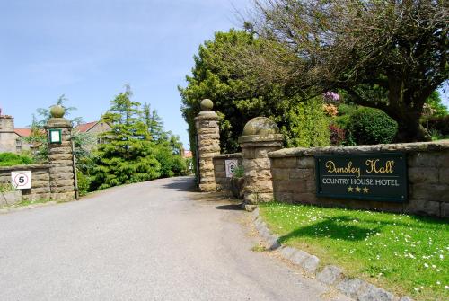 a driveway leading to a house with a sign at Dunsley Hall Country House Hotel in Whitby