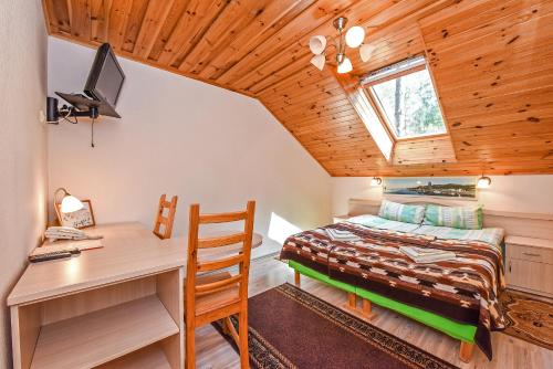a bedroom with a bed and a desk and a computer at Camping Mindunai in Mindūnai