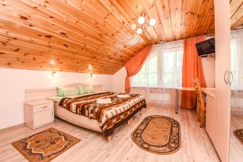 1 dormitorio con cama y techo de madera en Camping Mindunai, en Mindūnai