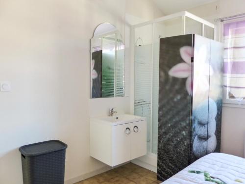 ein weißes Badezimmer mit einem Waschbecken und einem Spiegel in der Unterkunft vacances en bord de mer in Carqueiranne
