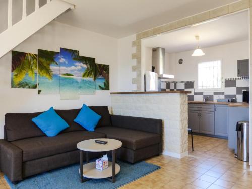 un salon avec un canapé et une cuisine dans l'établissement vacances en bord de mer, à Carqueiranne
