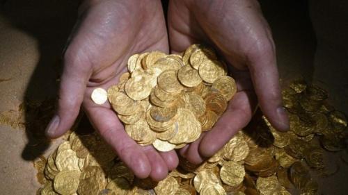 a person holding a pile of gold coins at Villa Alice Caesarea in Caesarea