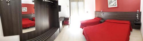 a red bedroom with a red couch and a mirror at Aer Hotel Malpensa in Oleggio