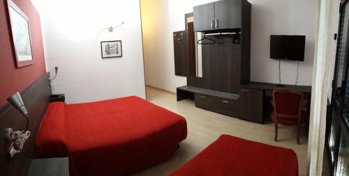 a hotel room with a red bed and a tv at Aer Hotel Malpensa in Oleggio