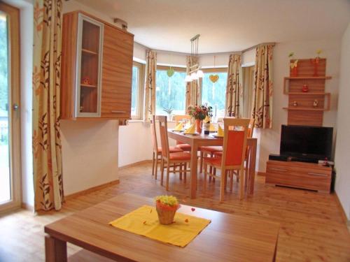 cocina y comedor con mesa y sillas en Landhaus Alpensonne, en Neustift im Stubaital