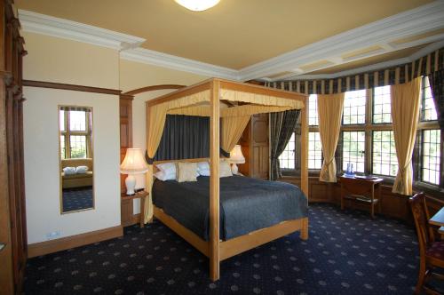 ein Schlafzimmer mit einem Himmelbett in einem Zimmer in der Unterkunft Dunsley Hall Country House Hotel in Whitby
