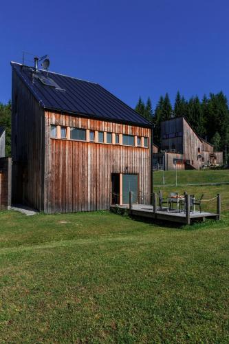 a large wooden barn in a field of grass at Chalet6harrachov se saunou in Harrachov