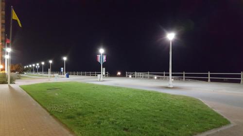 a parking lot with street lights at night at The Schooner Inn in Virginia Beach