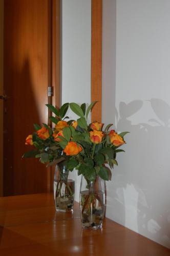a vase filled with orange flowers sitting on a table at Penzion Pri Slovenc in Dol pri Ljubljani
