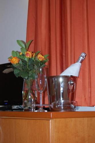 a bottle of champagne and glasses and a vase with flowers at Penzion Pri Slovenc in Dol pri Ljubljani
