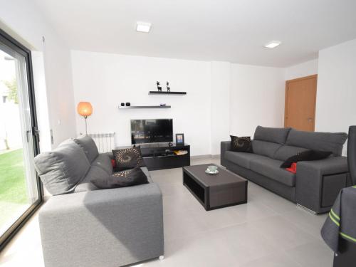 uma sala de estar com dois sofás e uma televisão em Modern villa with private swimming pool em Famalicão