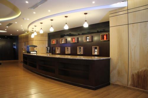 een bar in een kamer met foto's aan de muur bij AlMuhaidb Residence Alkhafji in Al Khafji