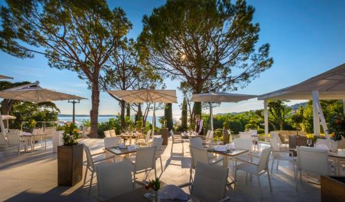 a wedding reception with white tables and chairs and umbrellas at Remisens BEL MORETTO - Hotel Metropol Annexe in Portorož