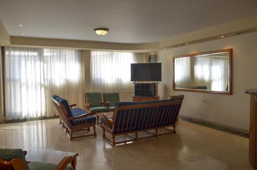 a living room with chairs and a flat screen tv at Hotel Costis in Ptolemaida