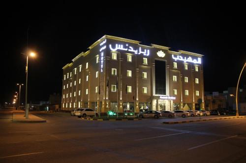 a lit up building with cars parked in a parking lot at AlMuhaidb Residence Alkhafji in Al Khafji