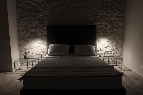 a bed in a room with a stone wall at Relais Casale Valigi in Narni