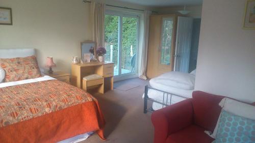 ein Schlafzimmer mit einem Bett, einem Stuhl und einem Fenster in der Unterkunft Thornybank in Cromer