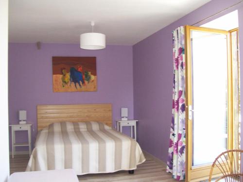 Les Rhodos في Noirpalu: غرفة نوم بجدران ارجوانية وسرير ومرآة