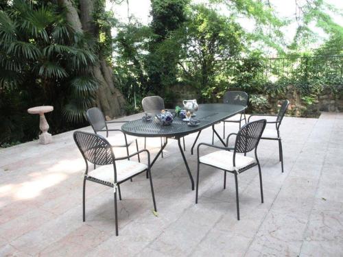 - une table et des chaises noires avec un bol de fleurs dans l'établissement Belvilla by OYO Villa Fiorita Tre, à Romano D'Ezzelino