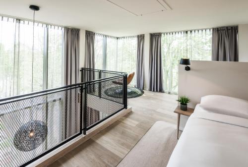 a bedroom with a balcony with a bed and a table at Hotel Arena in Amsterdam