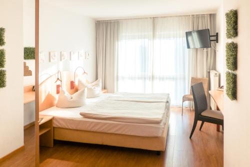 Una cama o camas en una habitación de Ambiente Langenhagen Hannover by Tulip Inn