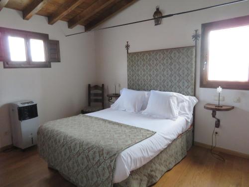 a bed room with a white bedspread and a white comforter at Palacio Rejadorada in Toro