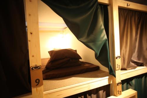 Cette chambre dispose de lits superposés et d'un miroir. dans l'établissement Base Inn Tabata, à Tokyo