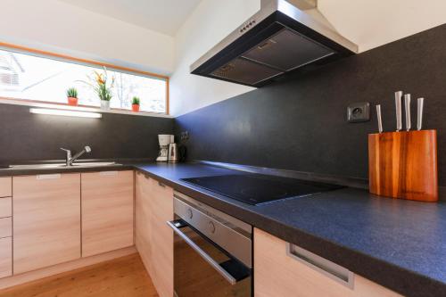 a kitchen with a black counter top and a sink at Chalet6harrachov se saunou in Harrachov