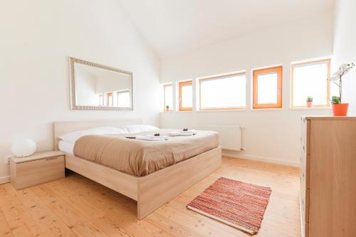 a white bedroom with a large bed and windows at Chalet6harrachov se saunou in Harrachov