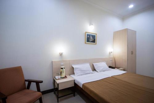 Habitación de hotel con cama y silla en Hotel Ranjeet en Agra