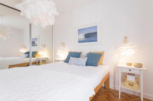 1 Schlafzimmer mit 2 Betten und einem Spiegel in der Unterkunft Pina I by An Island Apart in Funchal